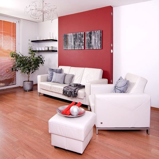 Realizacje projektów,małe mieszkanie,minimalizm, nowoczesne, biała kanapa i fotel skórzany na tle czerwonej ściany,Małe mieszkanie dla rodziny