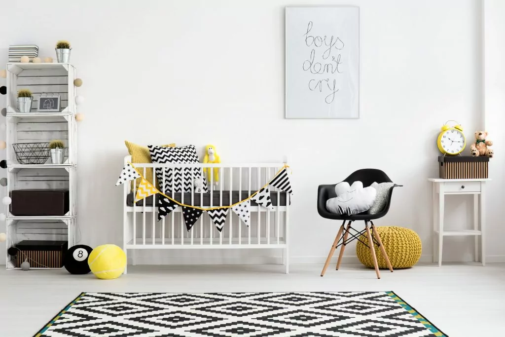 Pokój dziecka- dekoracje, pokój chłopca w kolorach czarno żółtych, na podłodze dywan w czarne geometryczne wzory,czarny fotel i żółta pufa