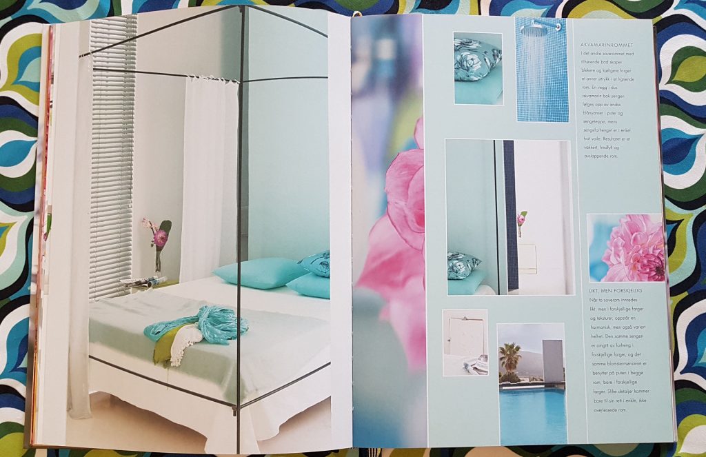 Tkaniny we wnętrzu,Album z fotografiami Tricia Guild leży na stole, widoczna fotografia nowoczesna sypialnia, w tle kolorowe tkaniny