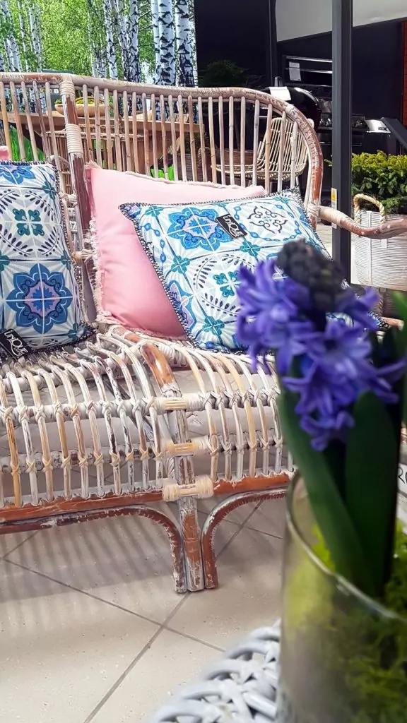 Targi Green Days, meble ogrodowe, meble z rattanu, Garden Space, sofa z rattanu z niebieskimi poduszkami, różowa poduszka, na pierwszym planie fioletowy hiacynt