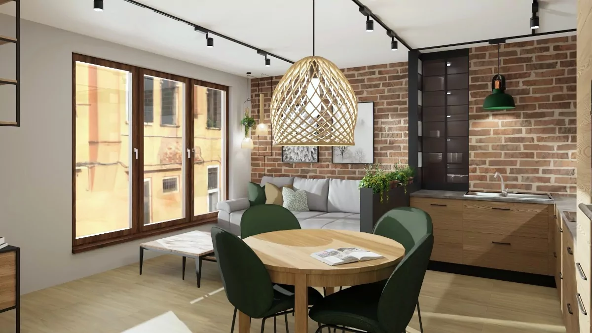 Małe mieszkanie projekt, kawalerka, cagła na ścianie zielone krzesła, okrągły stół, wiklinowa lampa, szara kanapa